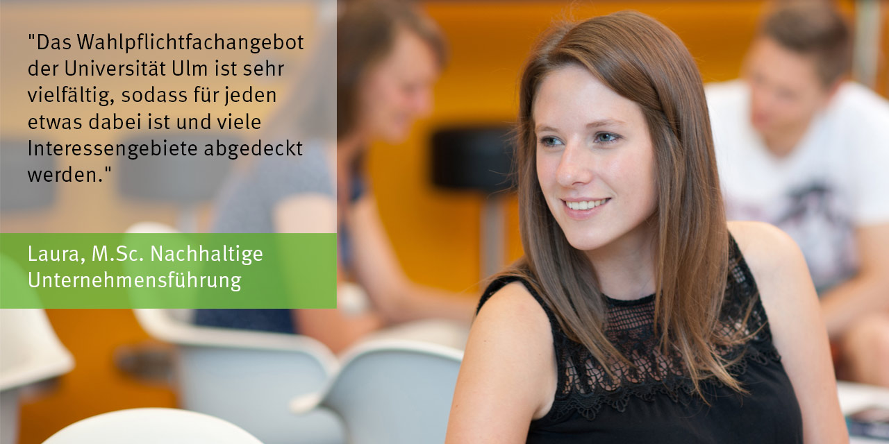 Eine Studentin mit langen, braunen Haaren im Profil sitzt auf einem Stuhl und schaut nach links. Man sieht nur den Oberkörper. Im Hintergrund weitere Studierende. 