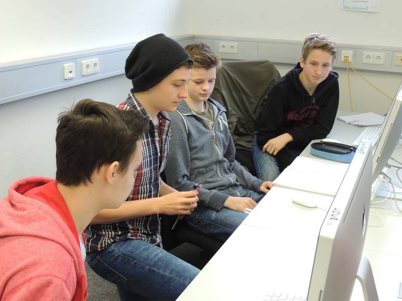 Eine Gruppe Schüler in einem Seminarraum an PCs.