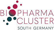 Das Logo des Biopharma Cluster Süddeutschland zeigt den Schriftzug »BIOPHARMA CLUSTER SOUTH GERMANY« in Großbuchstaben. Die Wörter »BIOPHARMA CLUSTER« sind in einer serifenlosen Schrift in dunklem Rot gehalten, während »SOUTH GERMANY« in einer dünneren, graugrünen Schrift darunter steht. Links und zwischen den Buchstaben »B«, »I«, »O«, »P«, »H«, »A« und »R« sind unterschiedlich große, runde Kreise in dunklem Rot und Rosa angeordnet, die an Molekülstrukturen erinnern. English: The logo for Biopharma Cluster South Germany features the words 'BIOPHARMA CLUSTER SOUTH GERMANY' in uppercase letters. 'BIOPHARMA CLUSTER' is written in a dark red sans-serif font, while 'SOUTH GERMANY' appears below in a thinner, gray-green font. To the left and between the letters 'B', 'I', 'O', 'P', 'H', 'A', and 'R', there are several round circles in dark red and pink, arranged to resemble molecular structures.