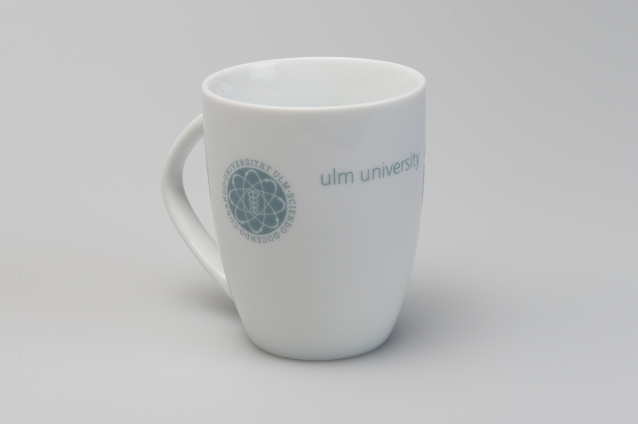 weiße Porzellantasse mit Uni-Logo, Ansicht von links