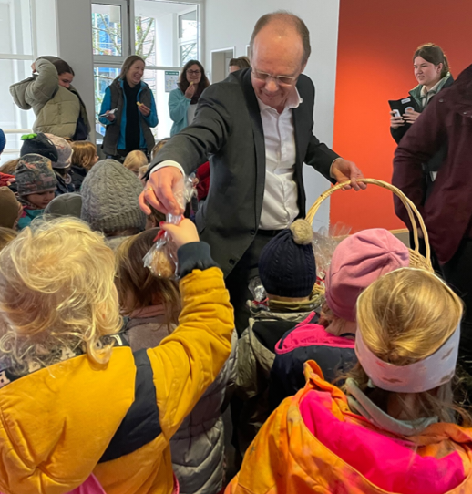 Der Präsident verteilt Präsenttütchen an die Kinder 