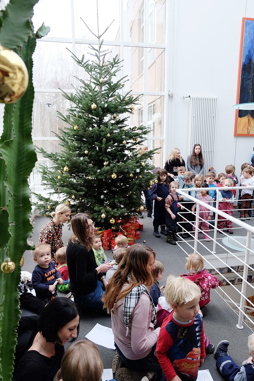 seitlicher Blick auf Kinder vor dem Weihnachtsbaum
