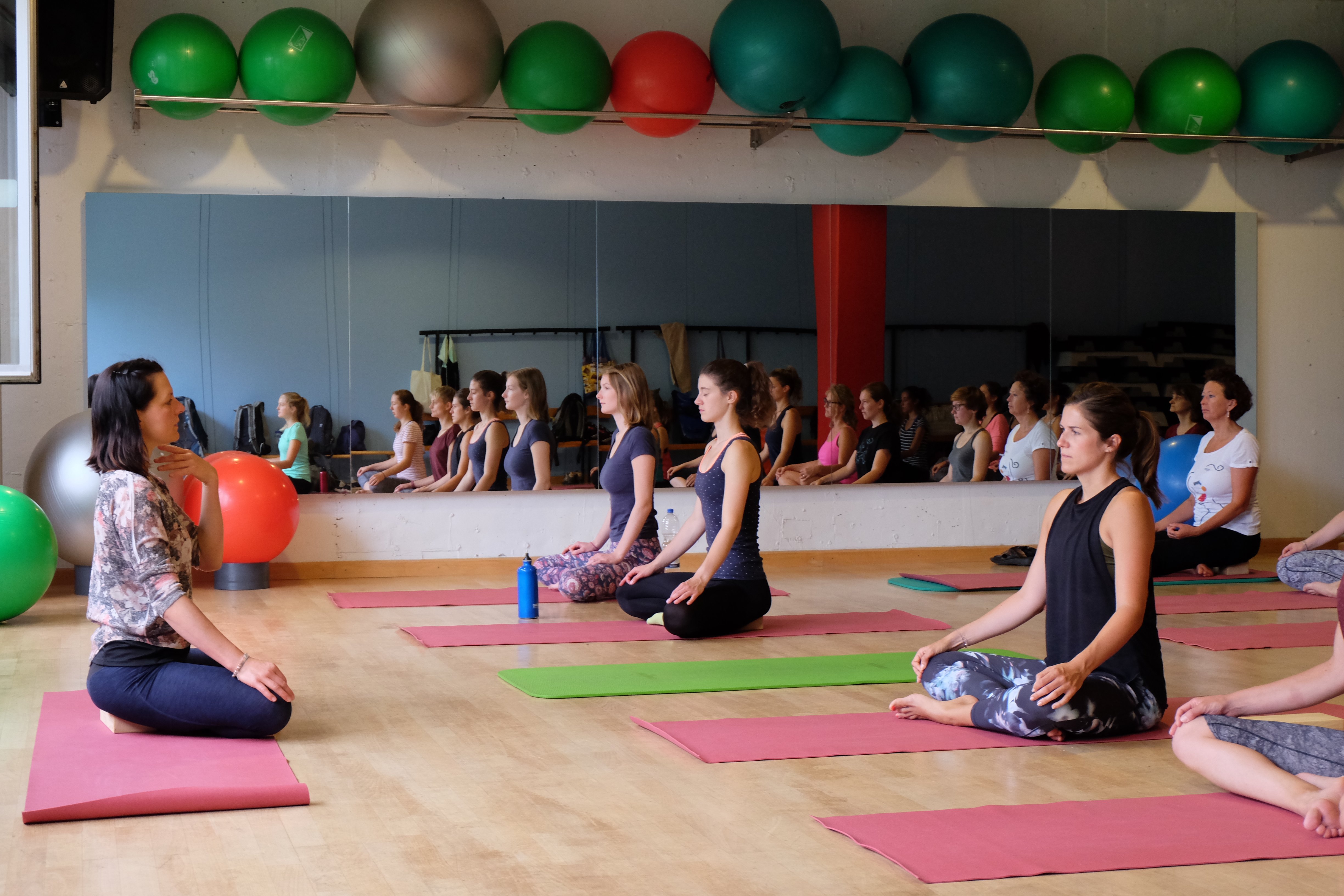 Picture of students sitting on the floor during a yoga course